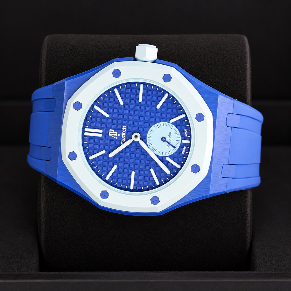 Royal Pop LAN BA horizontal dial view with blue rubber strap and light-blue crown at the top on a black cushion