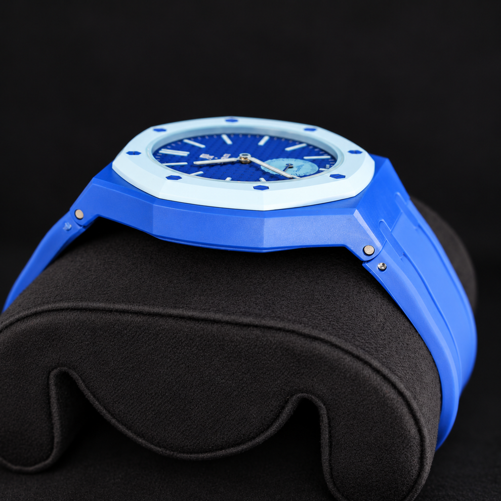 Royal Pop LAN BA low side profile showing blue case, light-blue bezel and blue rubber strap on a black cushion