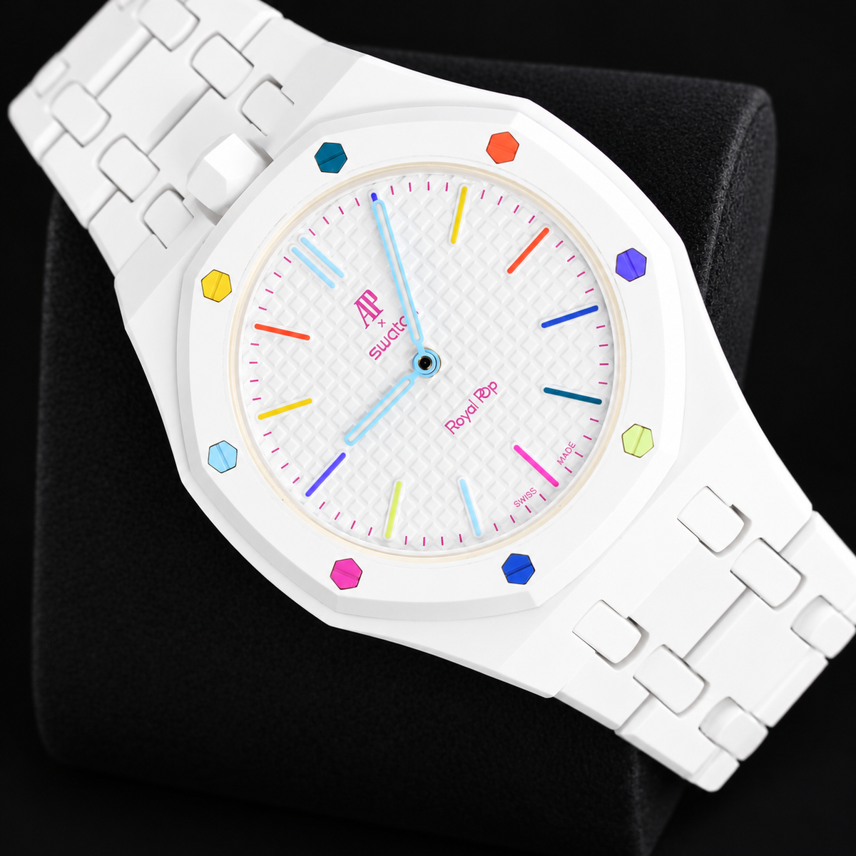 Royal Pop HUIT BLANC diagonal front view with white linked bracelet and multicoloured dial accents on a black cushion