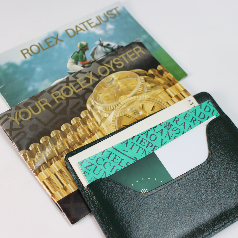 Rolex Datejust advertisement with a green card holder featuring Rolex branding.