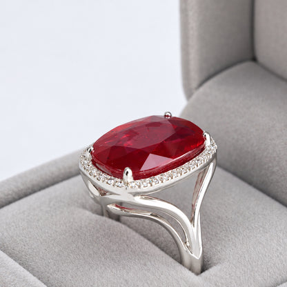 Close-up three-quarter view of 18ct white gold glass-filled ruby and natural diamond halo ring in its box