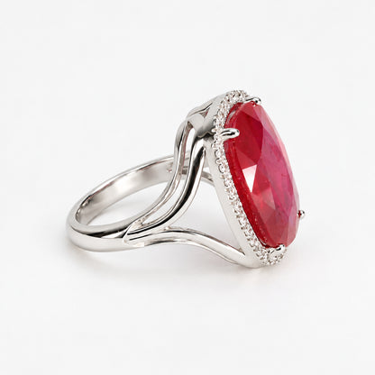Left-side profile of glass-filled ruby and natural diamond halo ring with sculptural white gold shoulders