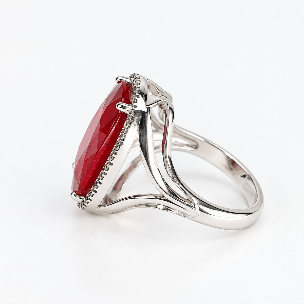 Right-side profile of 18ct white gold oval glass-filled ruby and natural diamond halo ring showing the raised setting