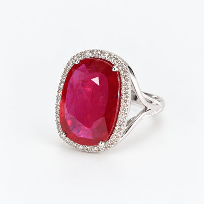 Three-quarter right view of 18ct white gold ruby ring showing oval glass-filled centre and surrounding diamonds