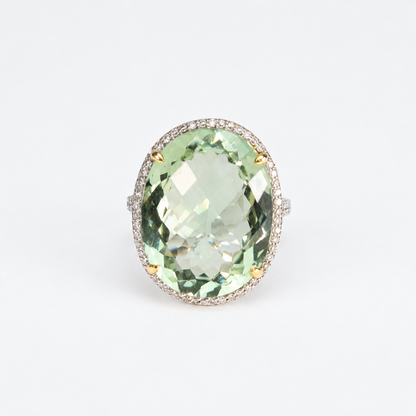Top view of oval pale green amethyst gemstone framed by a natural diamond halo in an 18ct white gold ring