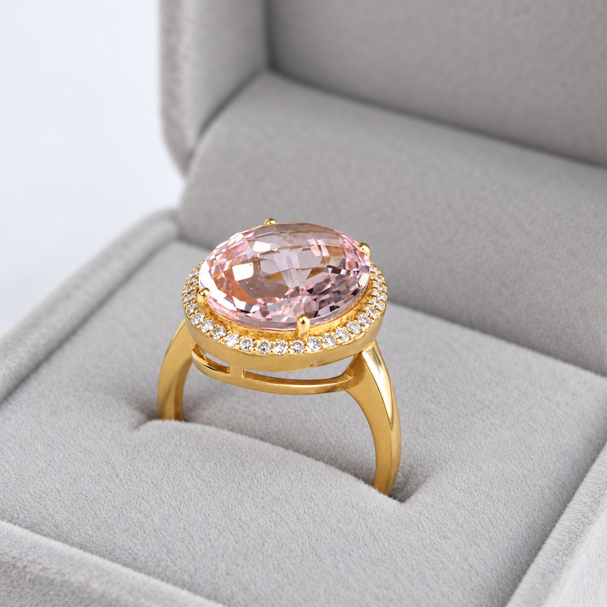 Close-up of faceted oval pink morganite and natural diamond surround in 18ct yellow gold