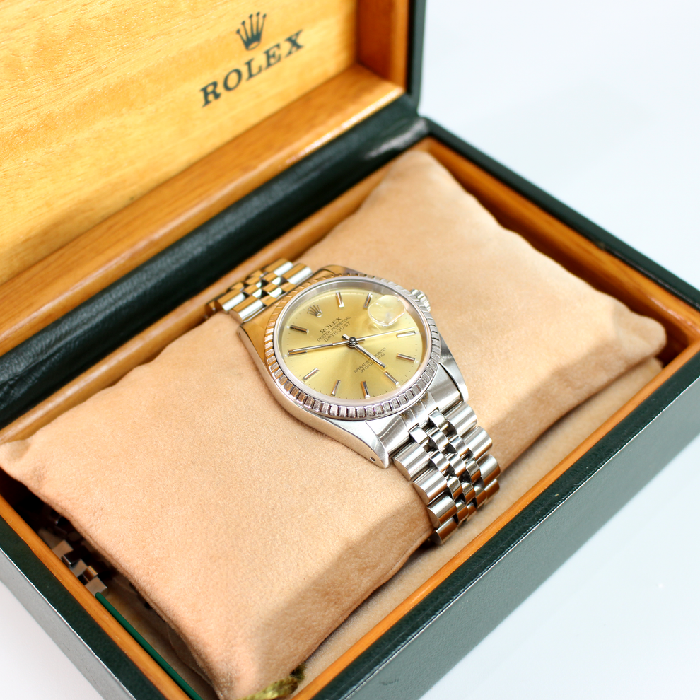 Vintage Rolex watch in a wooden box with a beige interior