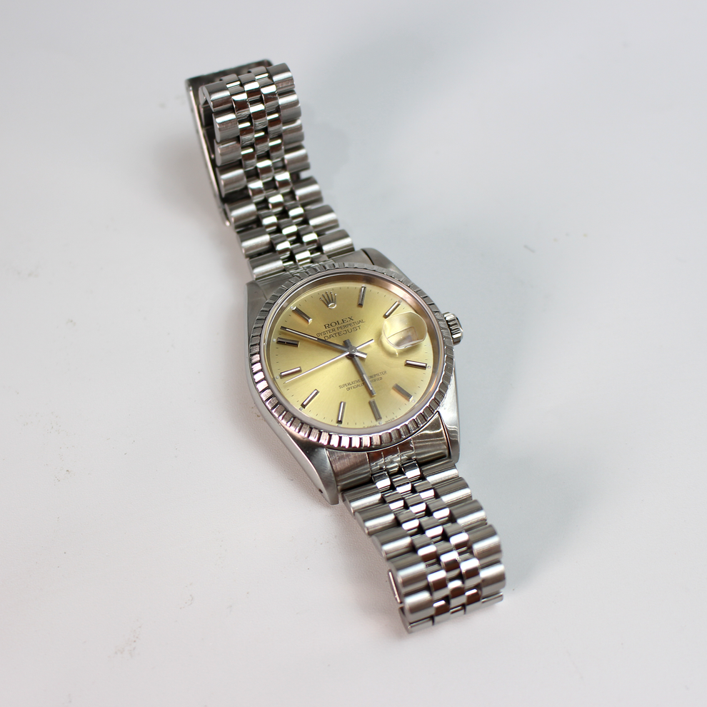 Silver watch with a gold face on a white background
