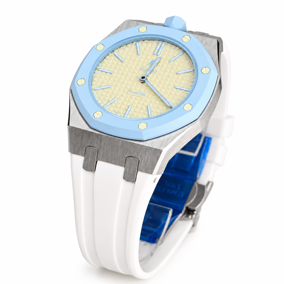 A luxury watch featuring a light blue bezel, a textured cream-colored dial, a brushed silver-tone case, and a white rubber strap with a blue interior.