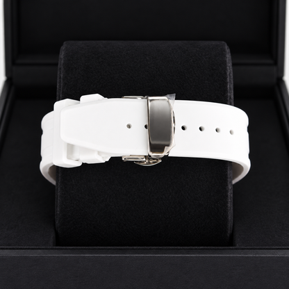 A white silicone watch strap with a silver-toned metal buckle, displayed on a black velvet watch cushion inside a black presentation box.
