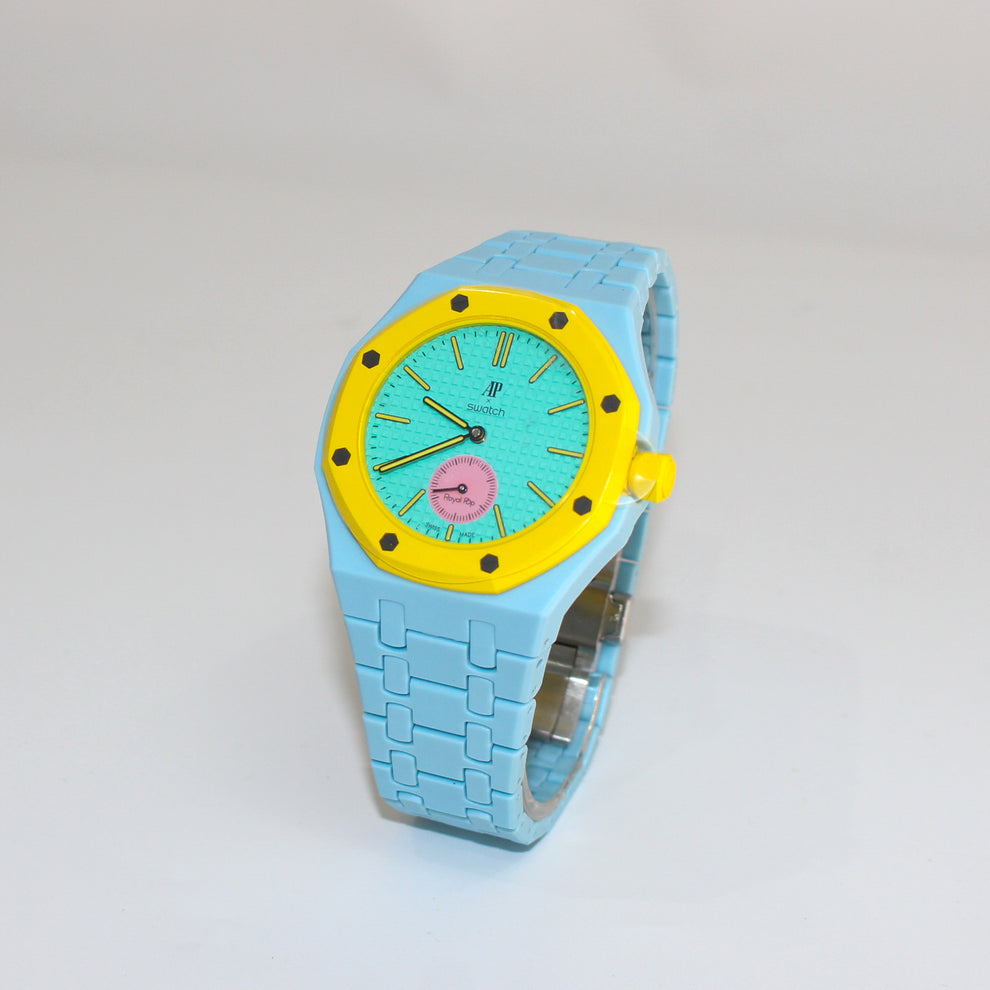 Swatch x Audemars Piguet Royal Pop OTG ROZ SSX03J100N with light blue Bioceramic bracelet, yellow bezel and teal dial, angled view