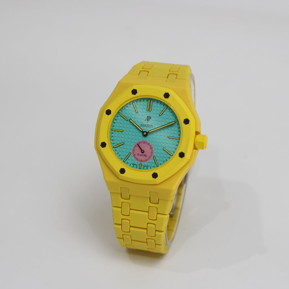 Swatch x Audemars Piguet Royal Pop OTG ROZ SSX03J100N with yellow Bioceramic bracelet, teal dial and pink small-seconds, angled view