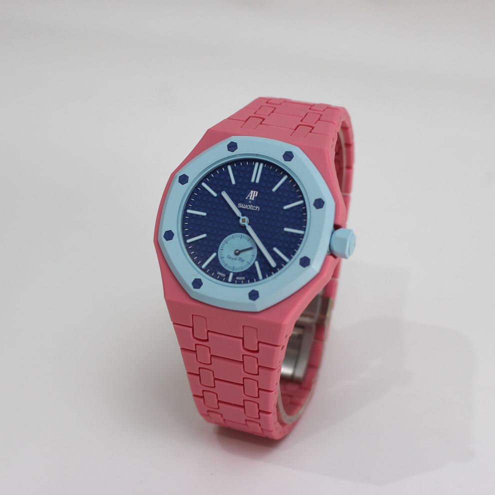 Royal Pop LAN BA angled view with pink linked bracelet and case, dark-blue dial and light-blue bezel