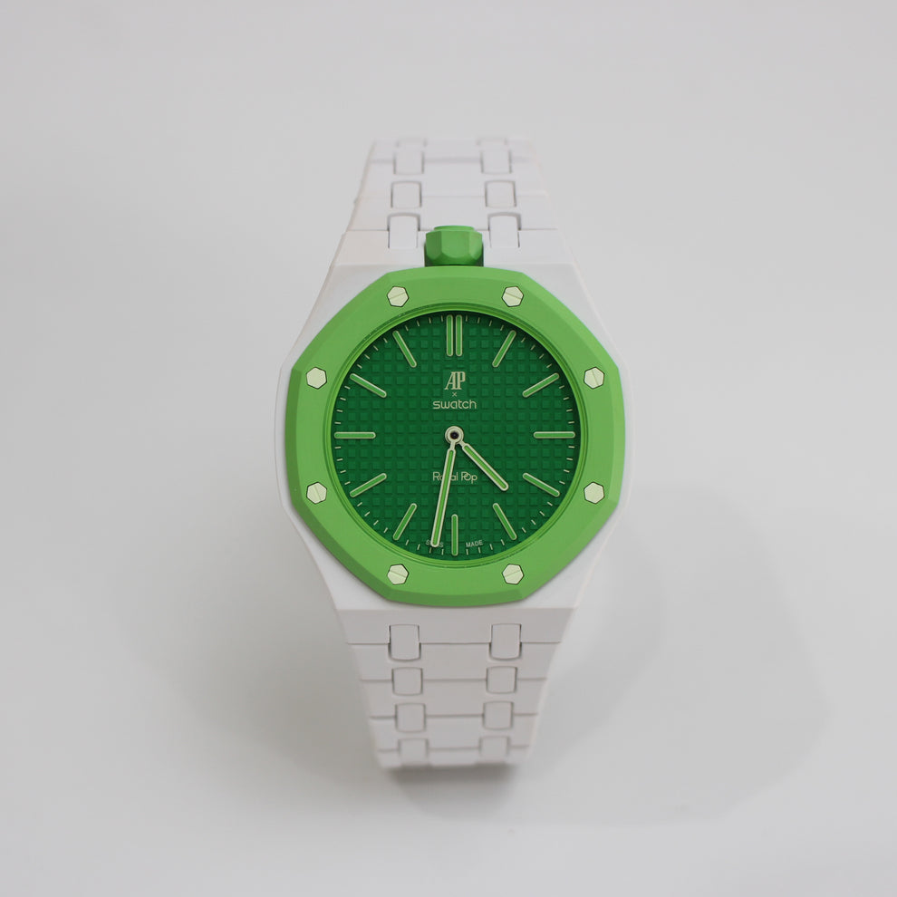 A Suison wristwatch featuring a white integrated link bracelet, a white case with a bright green bezel and crown, and a textured green dial with gold-tone indices.