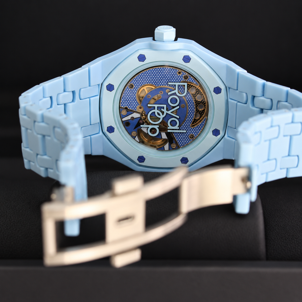 Royal Pop LAN BA transparent caseback showing the movement with light-blue linked bracelet and open folding clasp