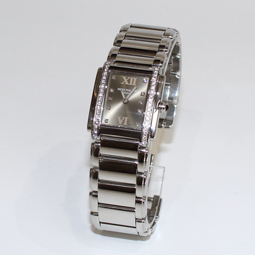 A silver-tone stainless steel women's watch with a rectangular dial, Roman numeral hour markers, crystal-set bezel, and matching metal link bracelet, photographed on a plain white background.