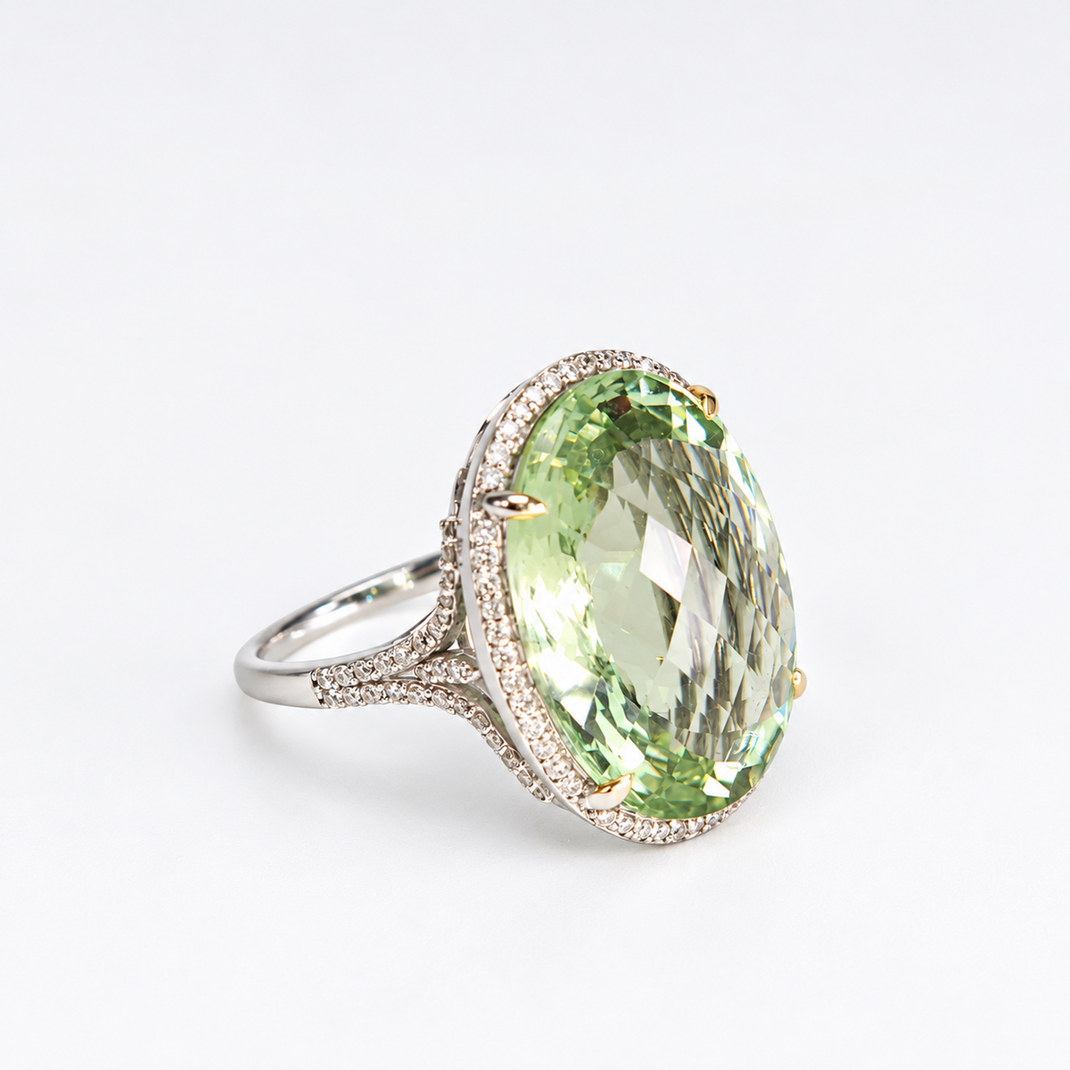 Angled view of large oval green amethyst ring with natural diamond halo and polished 18ct white gold setting