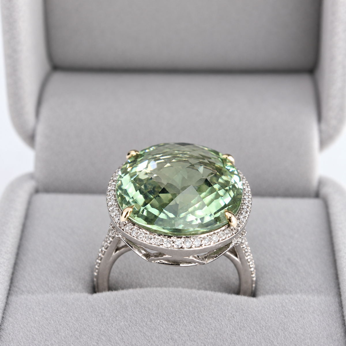 Front presentation-box view of large oval green amethyst cocktail ring with natural diamond halo